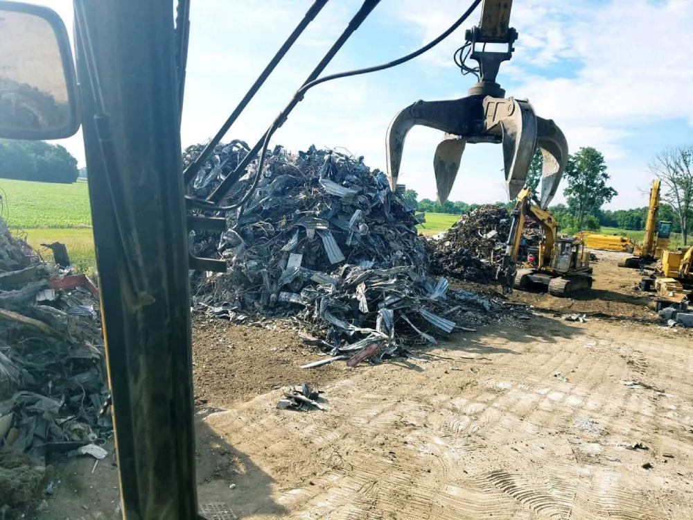 A large pile of metal is being loaded onto a truck.