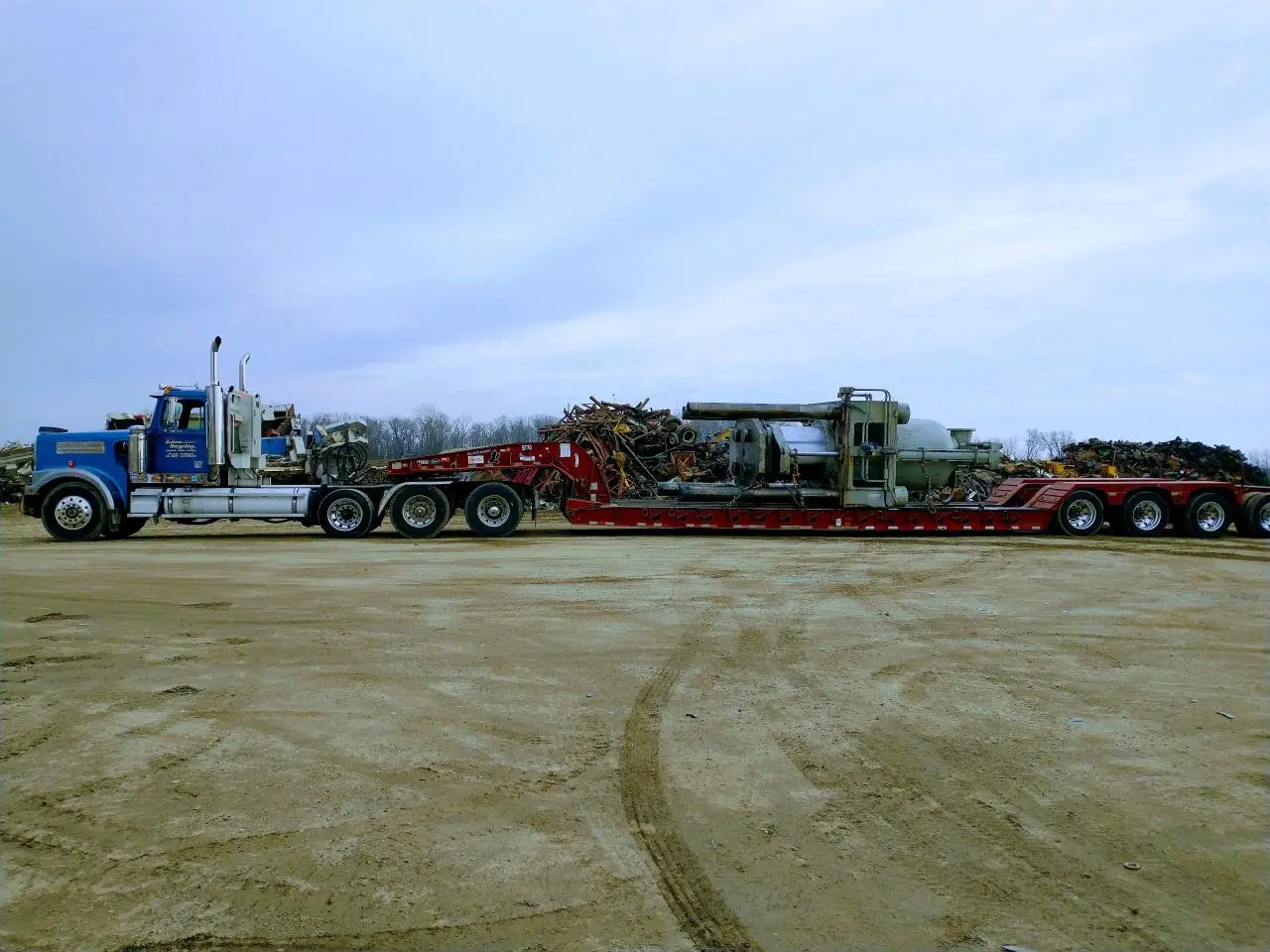 A large truck is parked in the dirt.